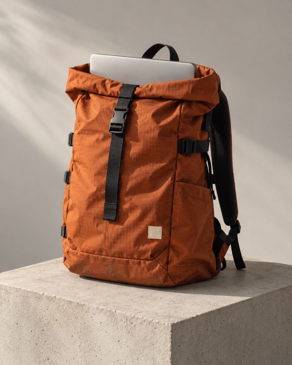 An orange technical rucksack with a silver laptop, ready for the journey.
